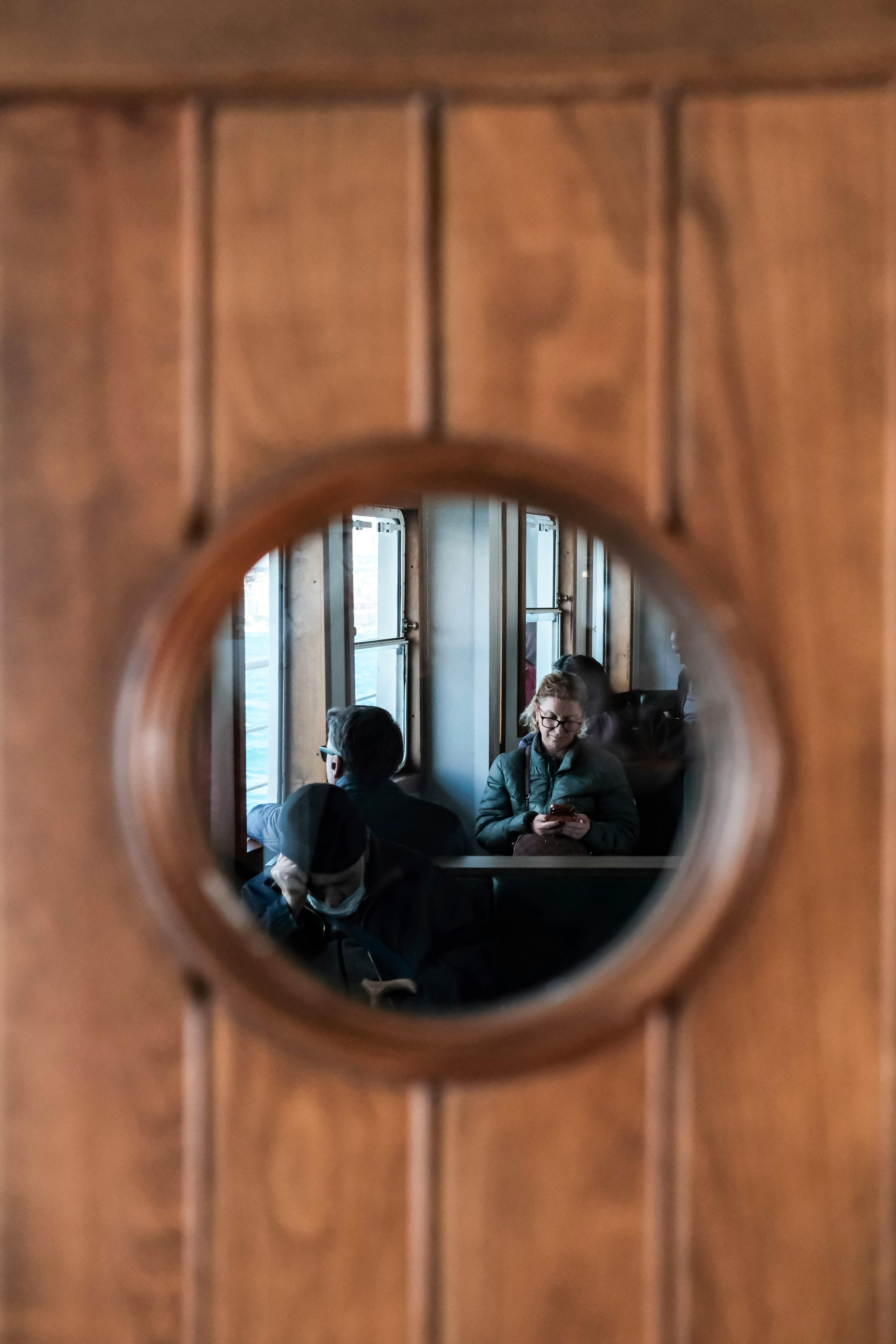 grátis Passageiros visíveis através da janela circular do bonde de Istambul, capturando o cotidiano dos deslocamentos diários. Foto profissional