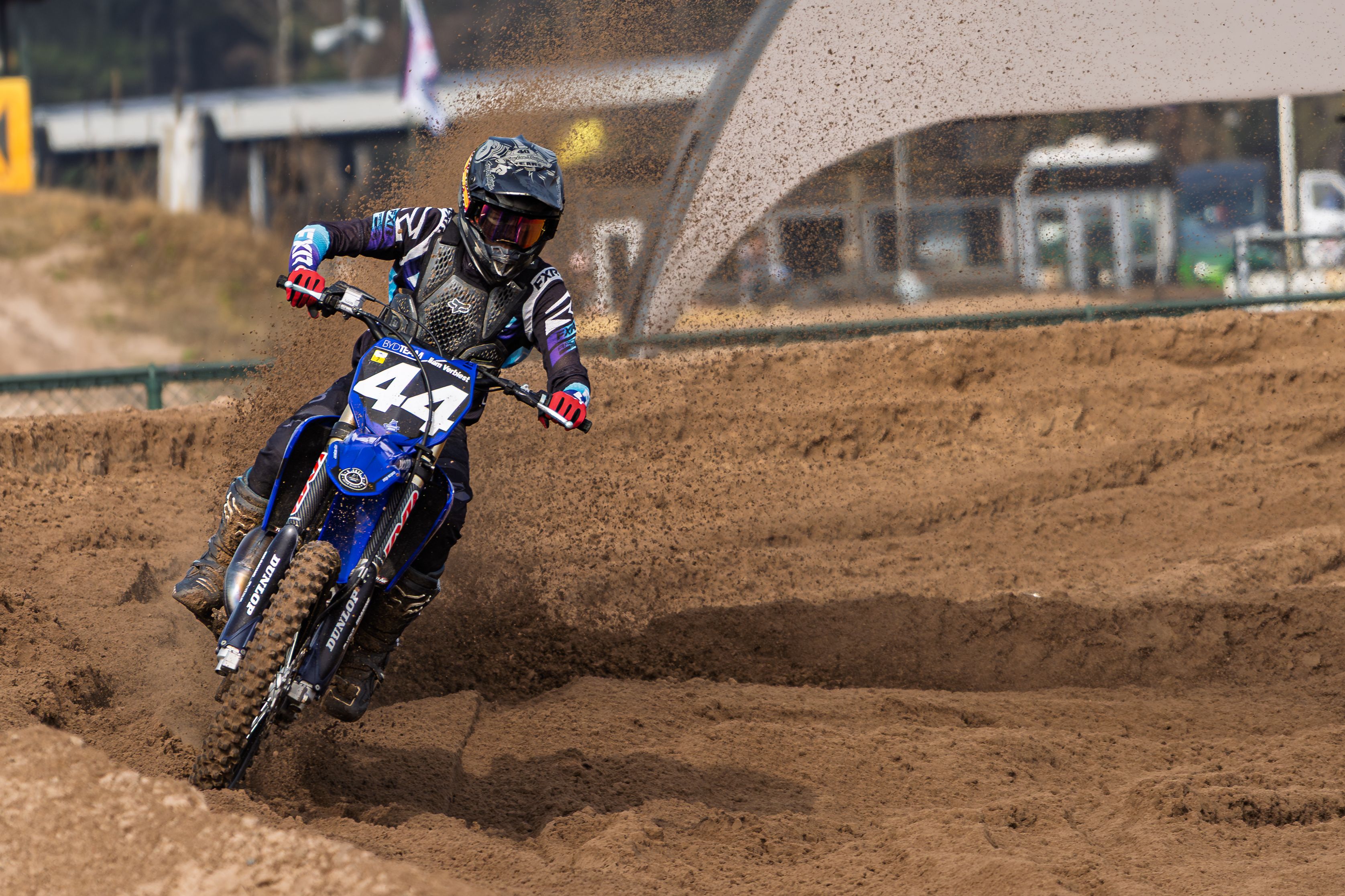 Thrilling action shot of a motocross rider navigating a dirt track, showcasing speed and skill.