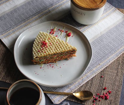 特写镜头中，舒适的桌子上摆放着甜华夫饼蛋糕片和咖啡