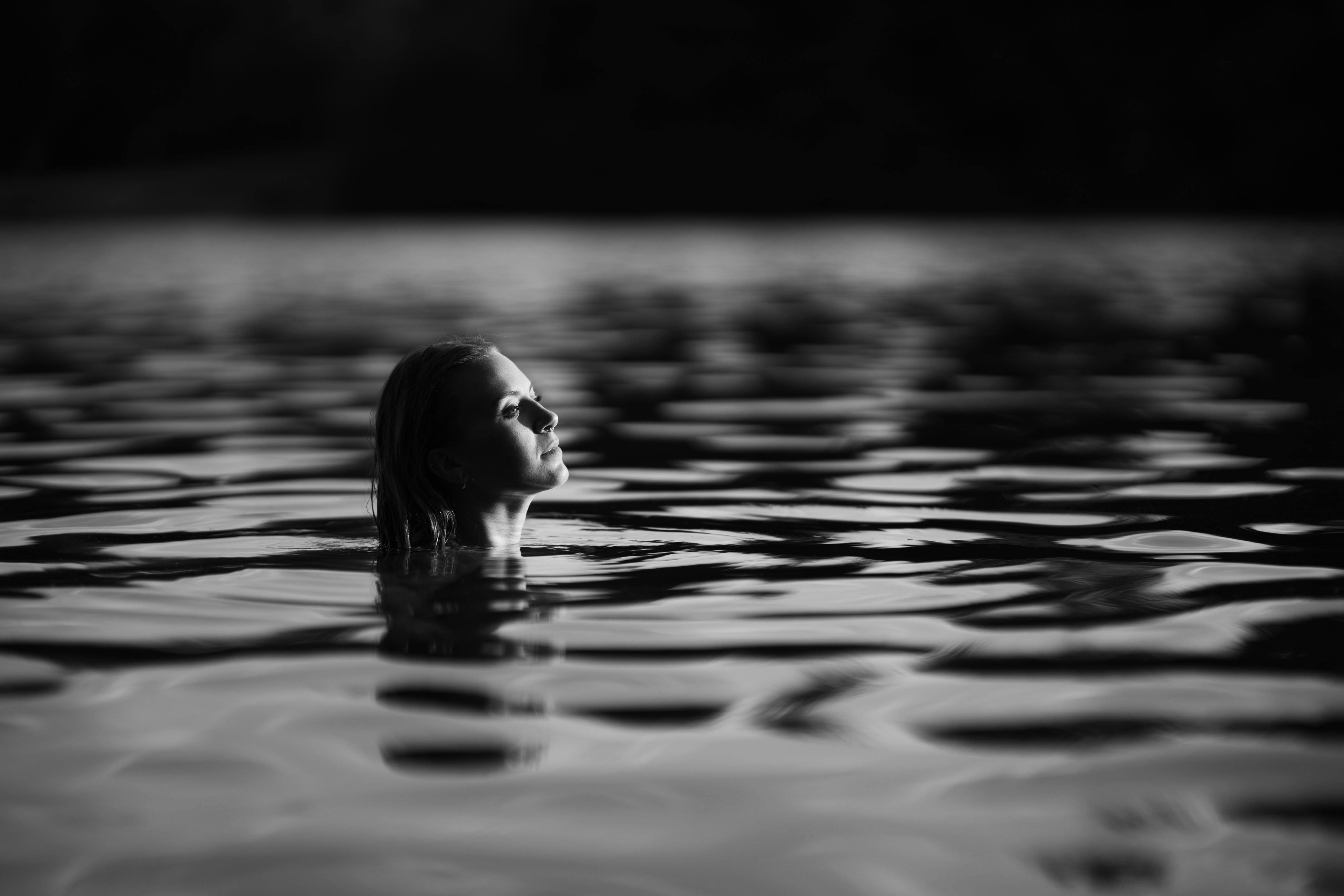 無料 水中にいる女性の穏やかなポートレートを白黒で撮影しました。 写真素材