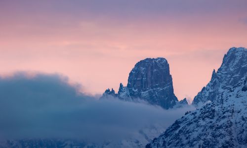 Free Breathtaking view of the Dolomites with snow-capped peaks at sunset, enveloped in clouds. Stock Photo