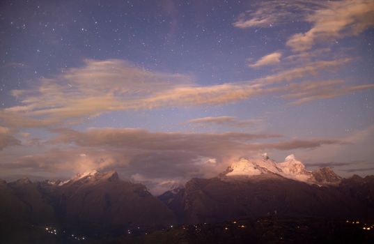 Stunning twilight view of snow-capped mountains in the Cordillera Blanca under a starry sky.