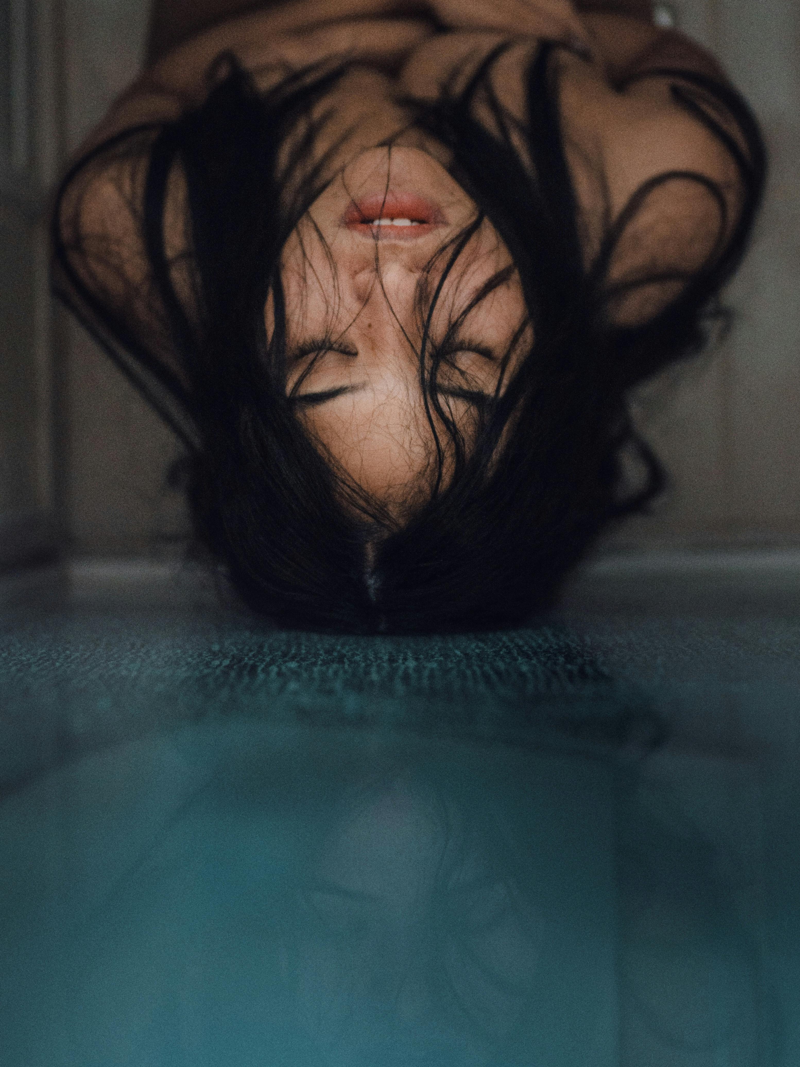 woman leaning on glass panel with head up