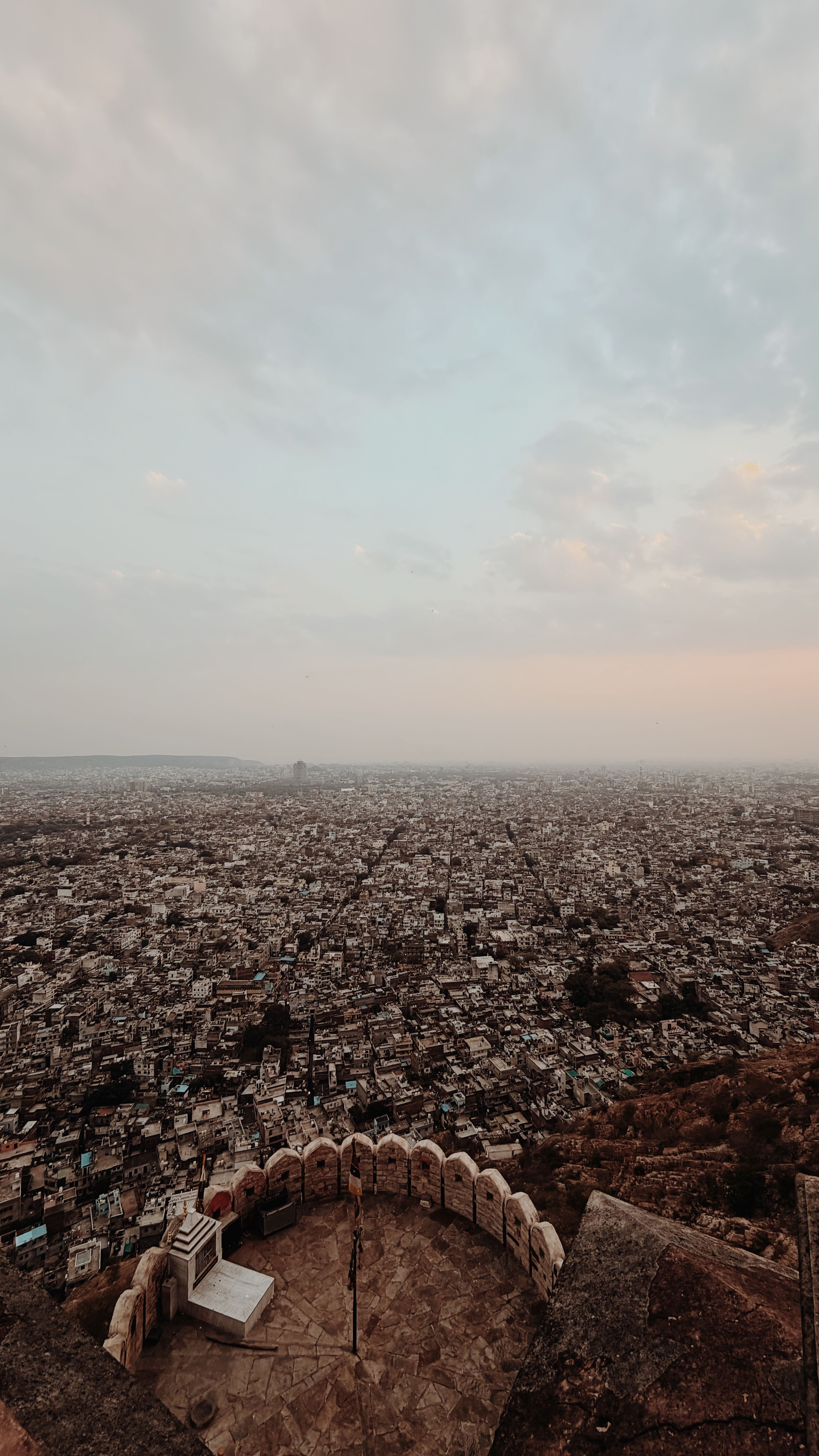 Stunning aerial image capturing the vast cityscape from a high vantage point during dusk with soft pastel skies.