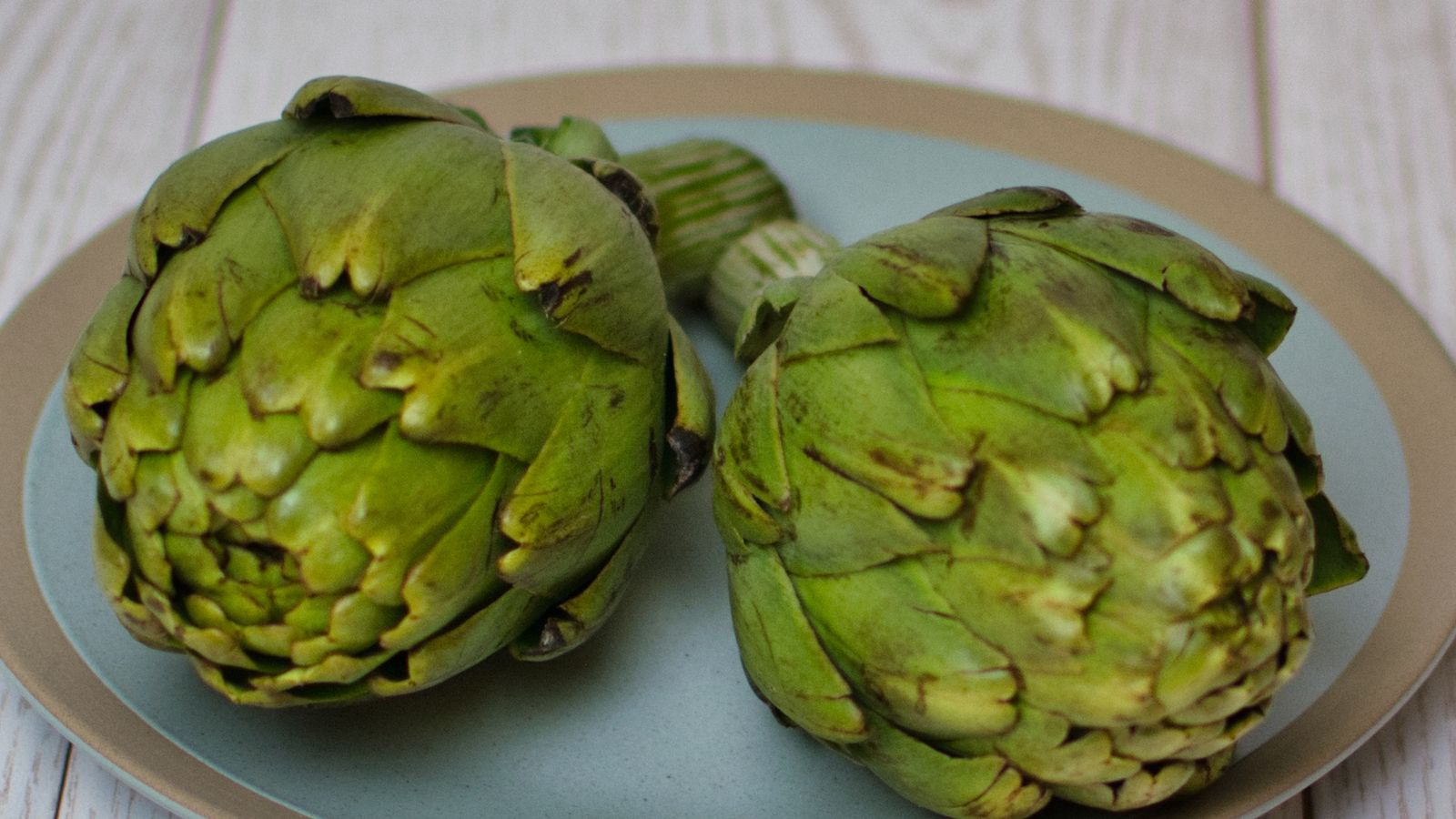 Fresh artichokes on a plate — photo by Andie on Pexels Fresh artichokes on a plate