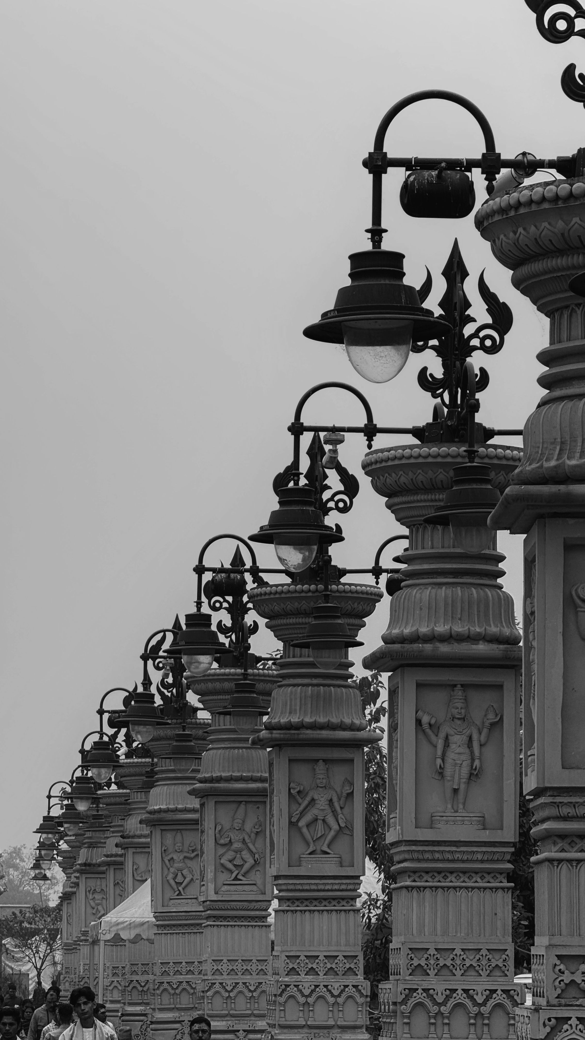 Striking black and white photo of traditional street lamps in India, showcasing intricate details.