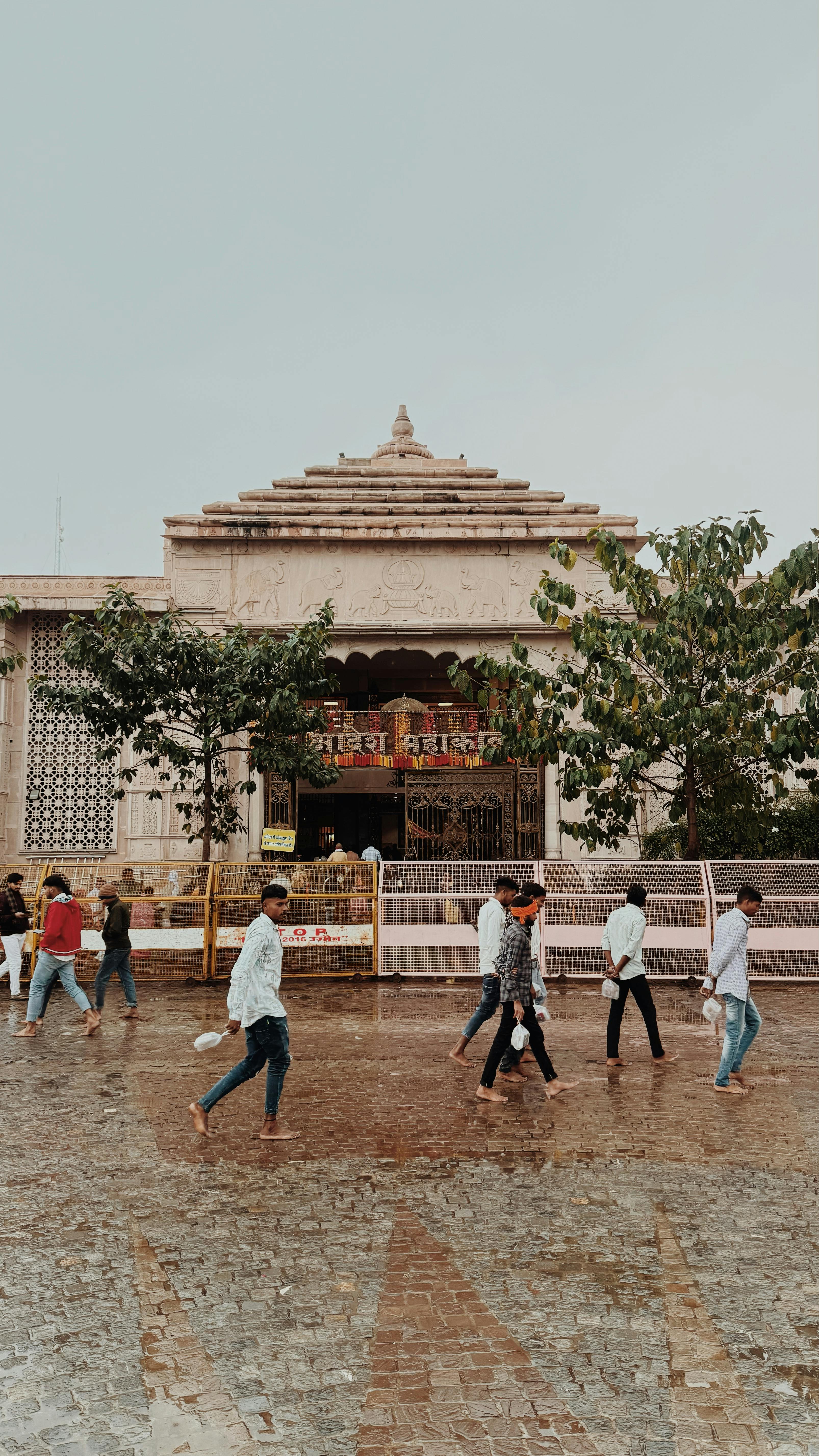 People walking outside a historic temple in Ujjain, India, showcasing cultural vibrancy.
