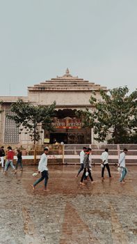 People walking outside a historic temple in Ujjain, India, showcasing cultural vibrancy. - Fotografer Sidoarjo