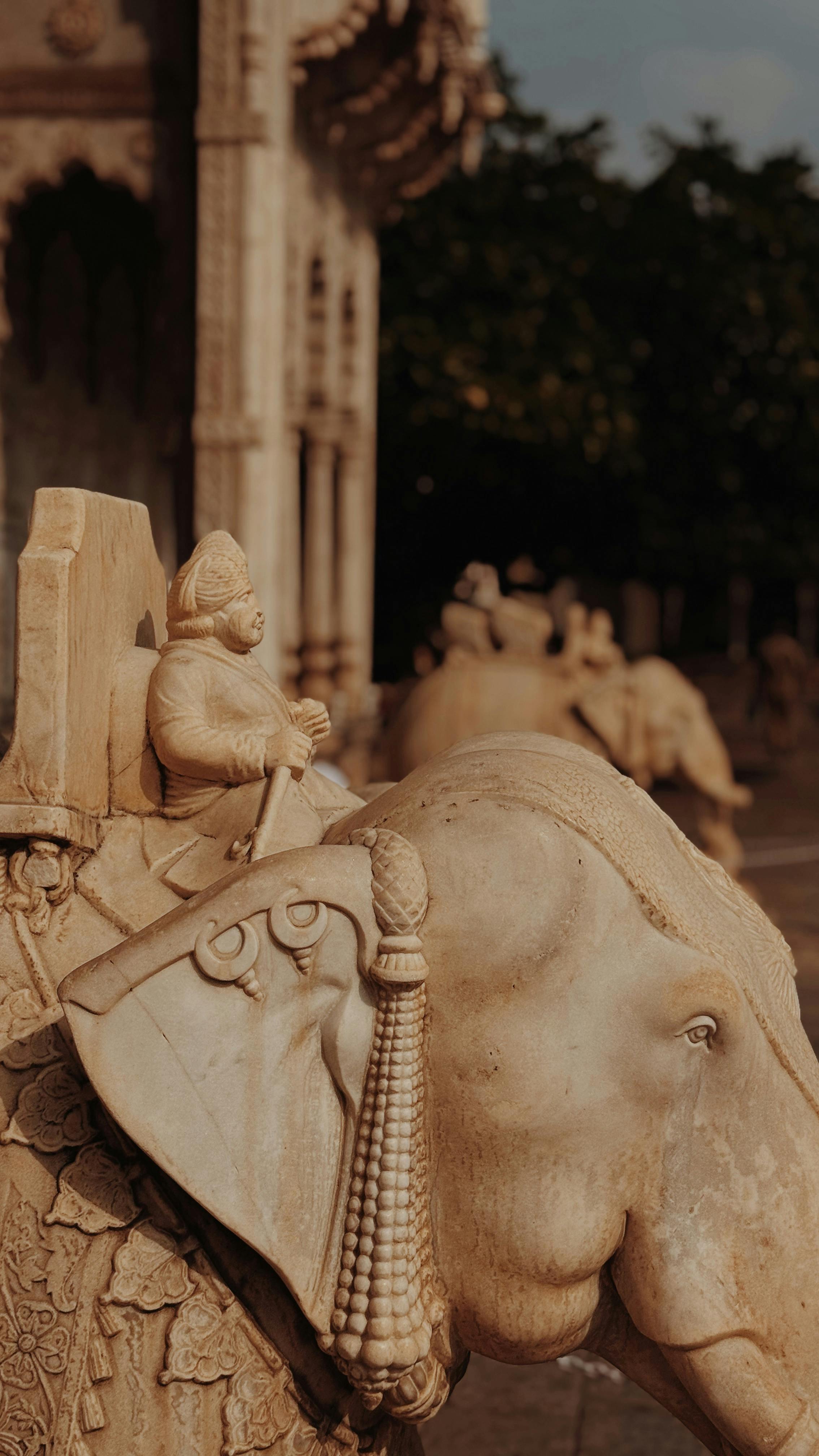 Detailed stone carving of an elephant with rider at a historic site in Jaipur, India.