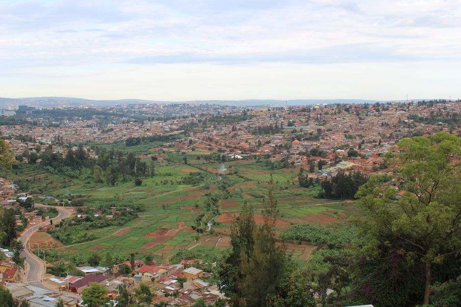 Aerial view of Kigali, Rwanda showcasing urban development and green fields.