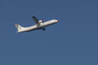 Airplane Flying Over Cinisi's Clear Blue Sky