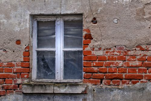 Free Rustic brick wall with an aged window, showcasing urban decay and architectural texture. Stock Photo