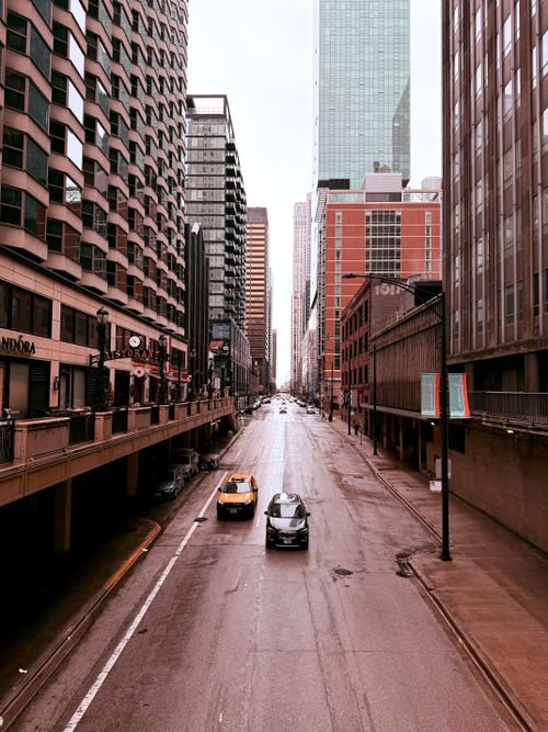 Free Rainy day view of a Chicago street flanked by towering skyscrapers. Stock Photo