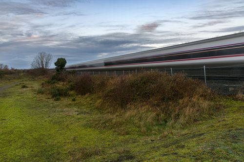 Free A high-speed train rushes through the green landscape of Craigavon, Northern Ireland, in the early evening. Stock Photo