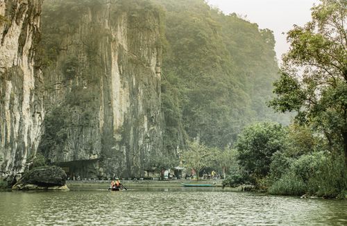 Free Tranquil river scene with limestone cliffs and a boat ride capturing the natural beauty. Stock Photo
