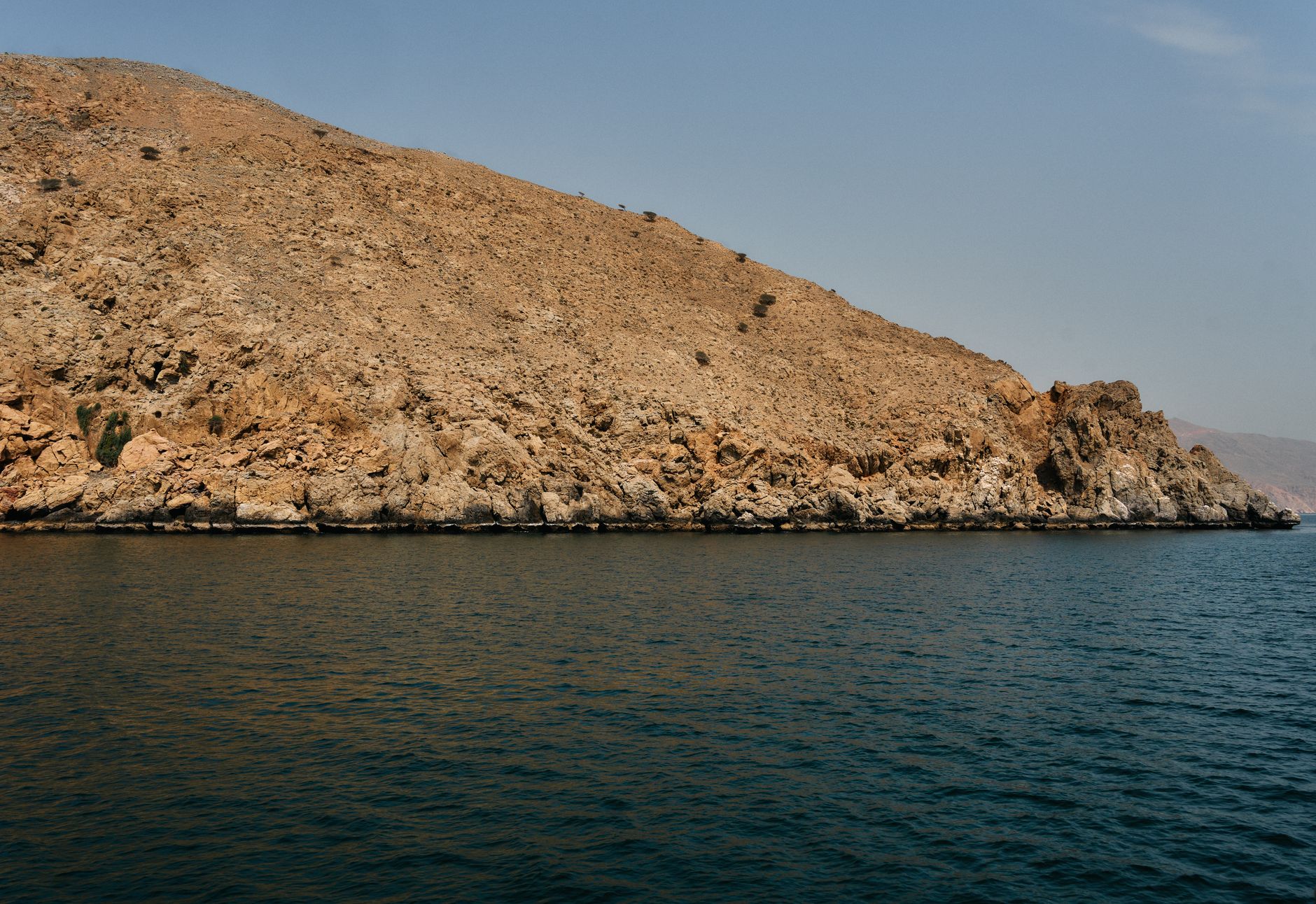 Explore the rugged cliffs and serene waters of Musandam Peninsula, a stunning natural landmark in Oman.