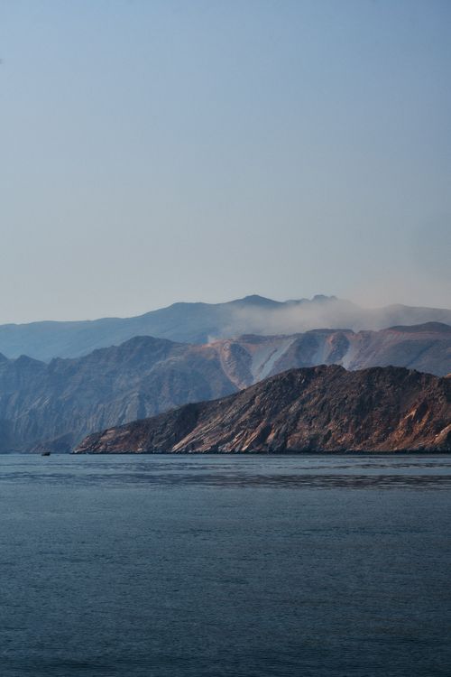 Free Serene view of the rocky coastline of Musandam Peninsula under clear blue sky. Stock Photo