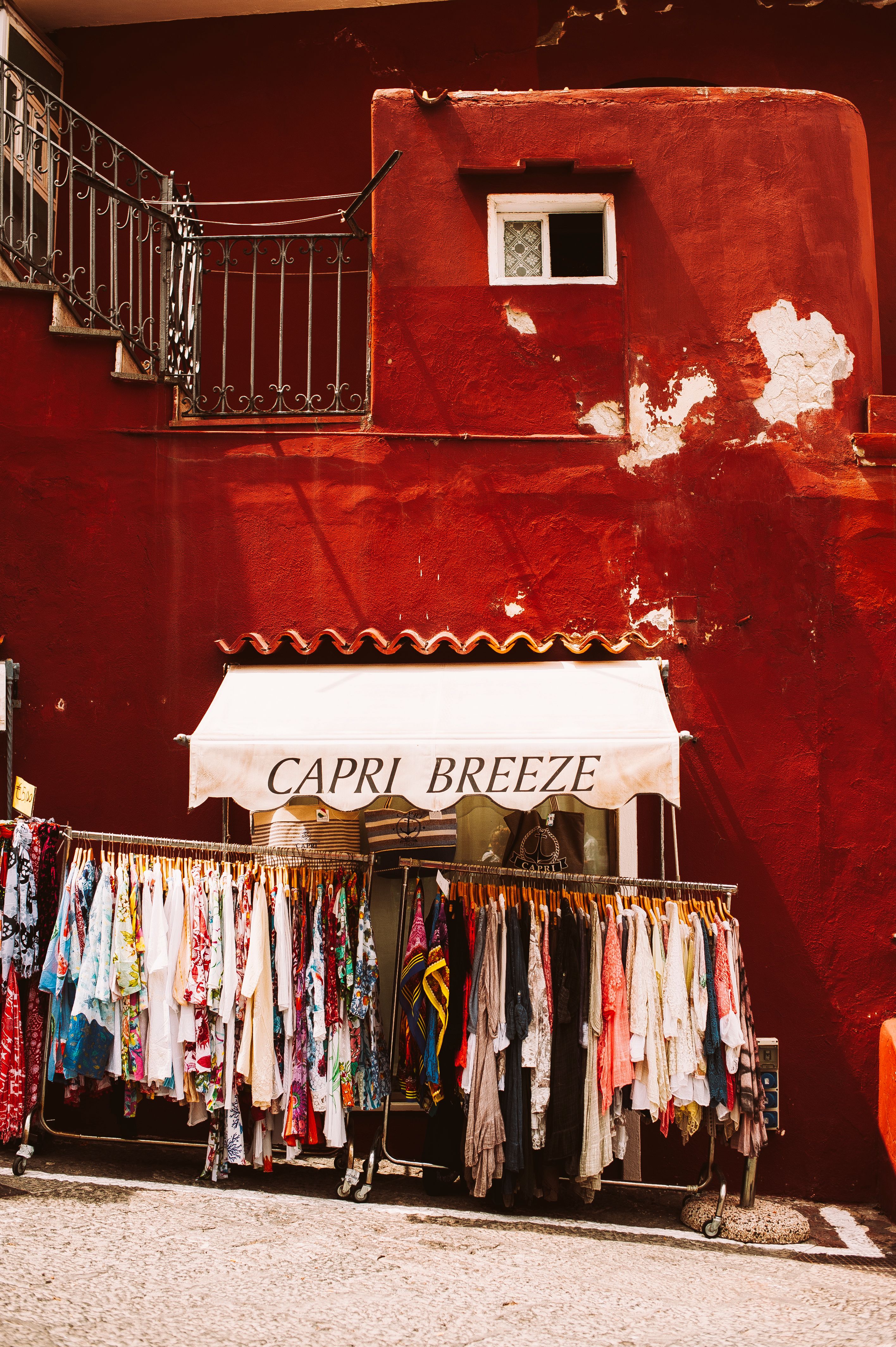 Vibrant storefront with assorted clothing in Capri, Italy.