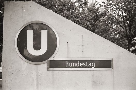 Vintage-style photo of the Bundestag U-Bahn station sign in Berlin.