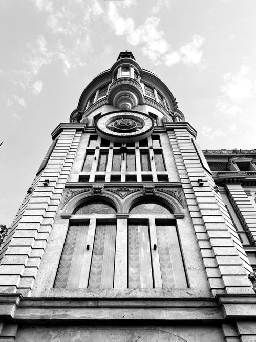 Free Dramatic black and white capture of historic building facade with intricate details and cloudy sky. Stock Photo