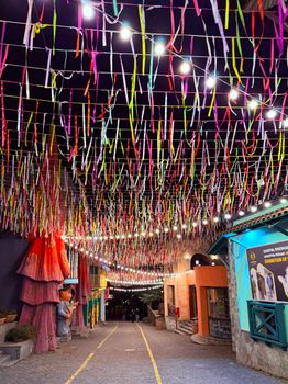 Colorful ribbons and festive lights creating a vibrant street atmosphere at night, perfect for celebrations.
