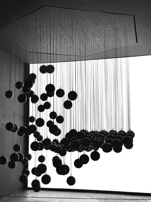 Free Dramatic black and white art installation with hanging spheres in modern setting. Stock Photo