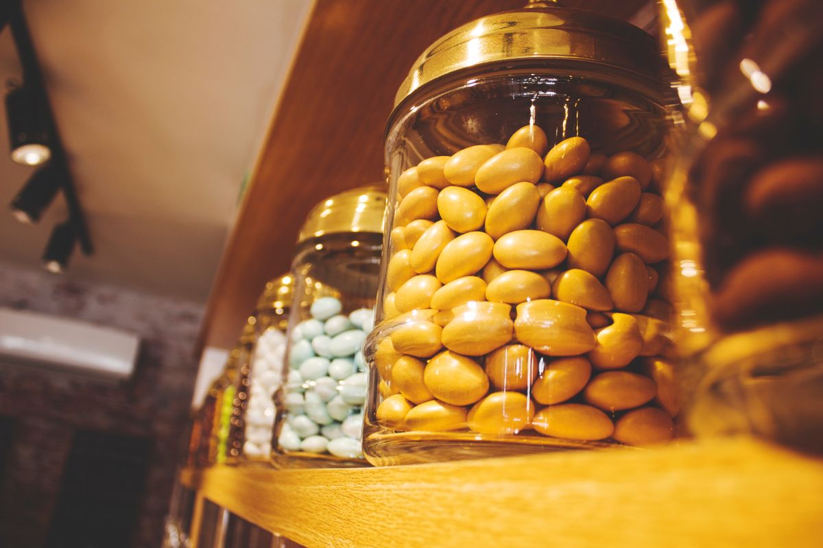 Candy jars lined up on a wooden shelf