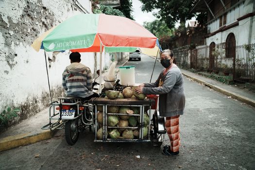 Street vendor selling fresh coconuts in Tagaytay City, Philippines.