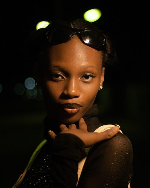 Free Stylish night portrait of a woman in a sparkling top wearing sunglasses on her head. Stock Photo