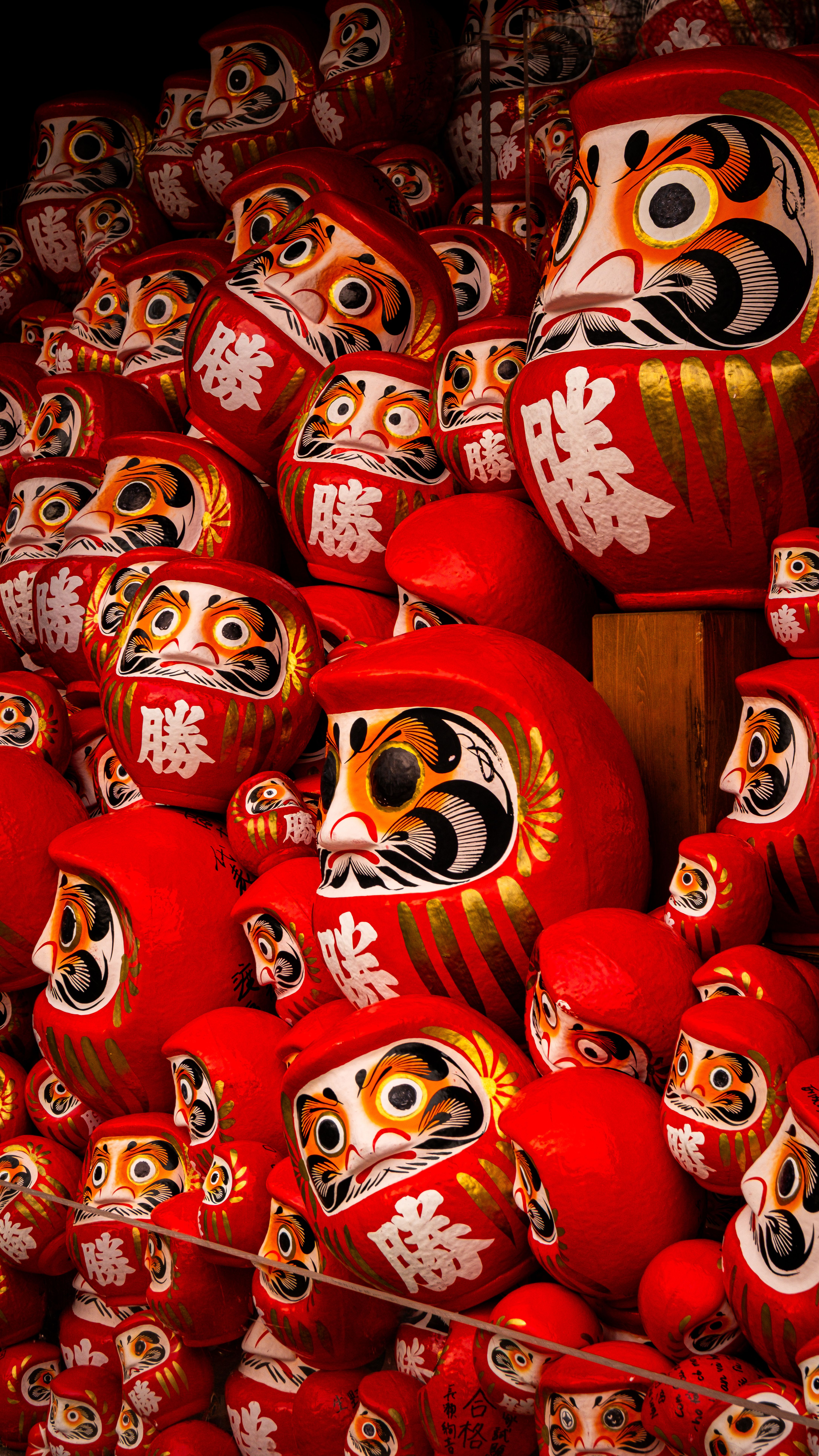 Colorful display of traditional Daruma dolls symbolizing perseverance in Minoh, Osaka, Japan.