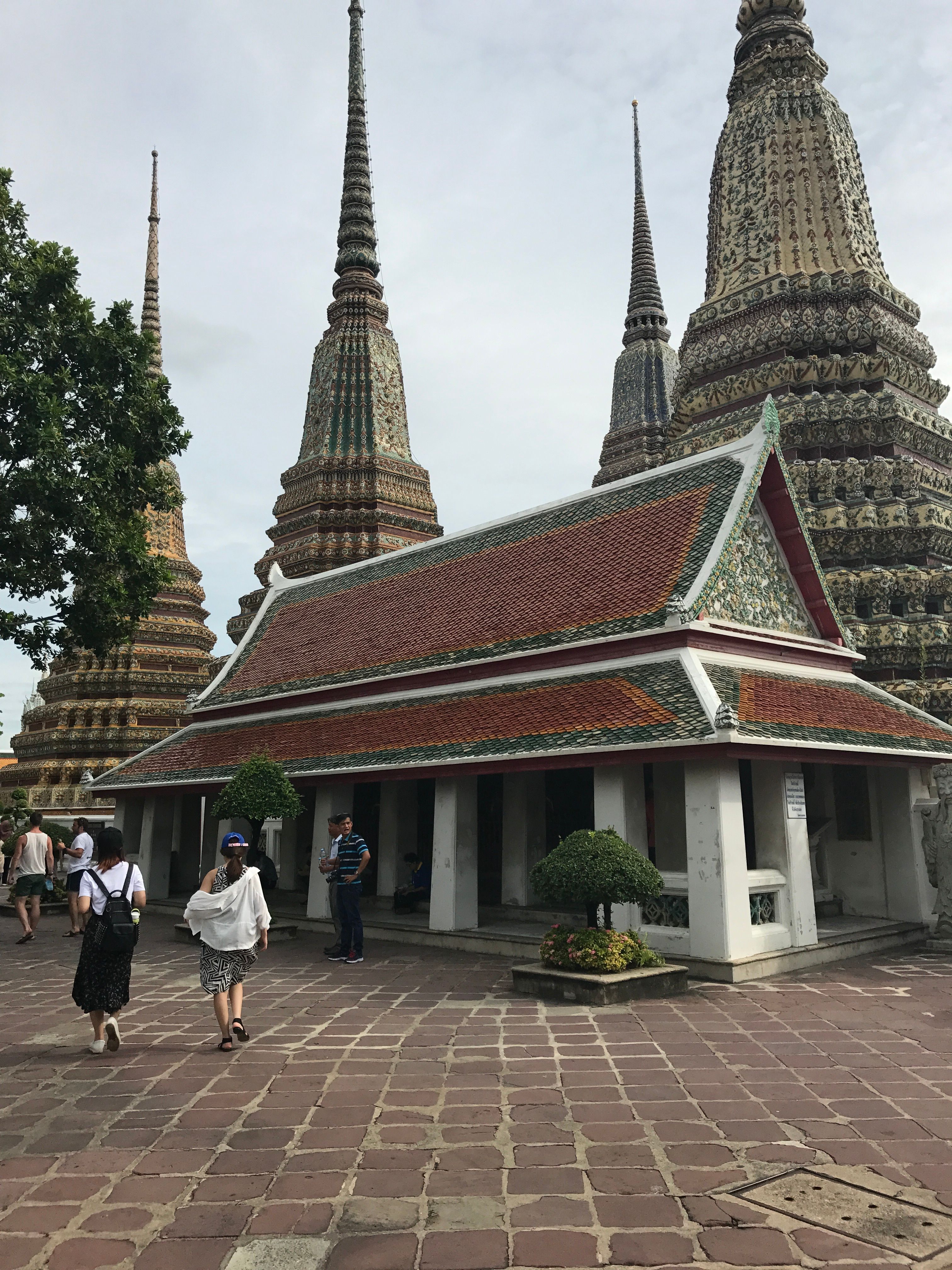 Kostenlos Erkunden Sie die wunderschönen Pagoden und die traditionelle Architektur von Wat Pho in Bangkok unter einem klaren Taghimmel. Stock-Foto