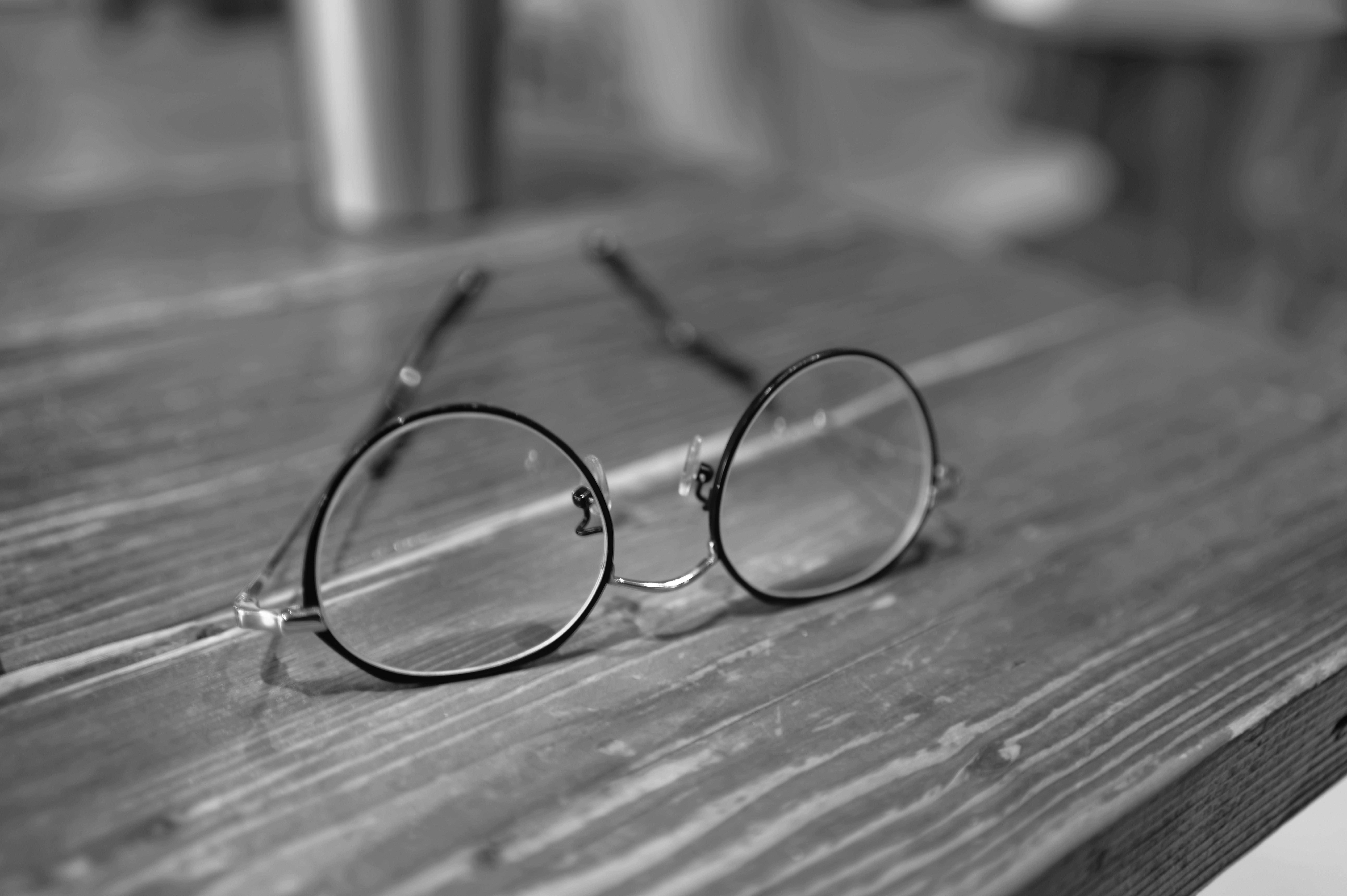 Δωρεάν Στρογγυλά vintage ποτήρια που ακουμπούν σε ένα ξύλινο τραπέζι, σε κλασικό ασπρόμαυρο φόντο. Φωτογραφία από στοκ φωτογραφιών