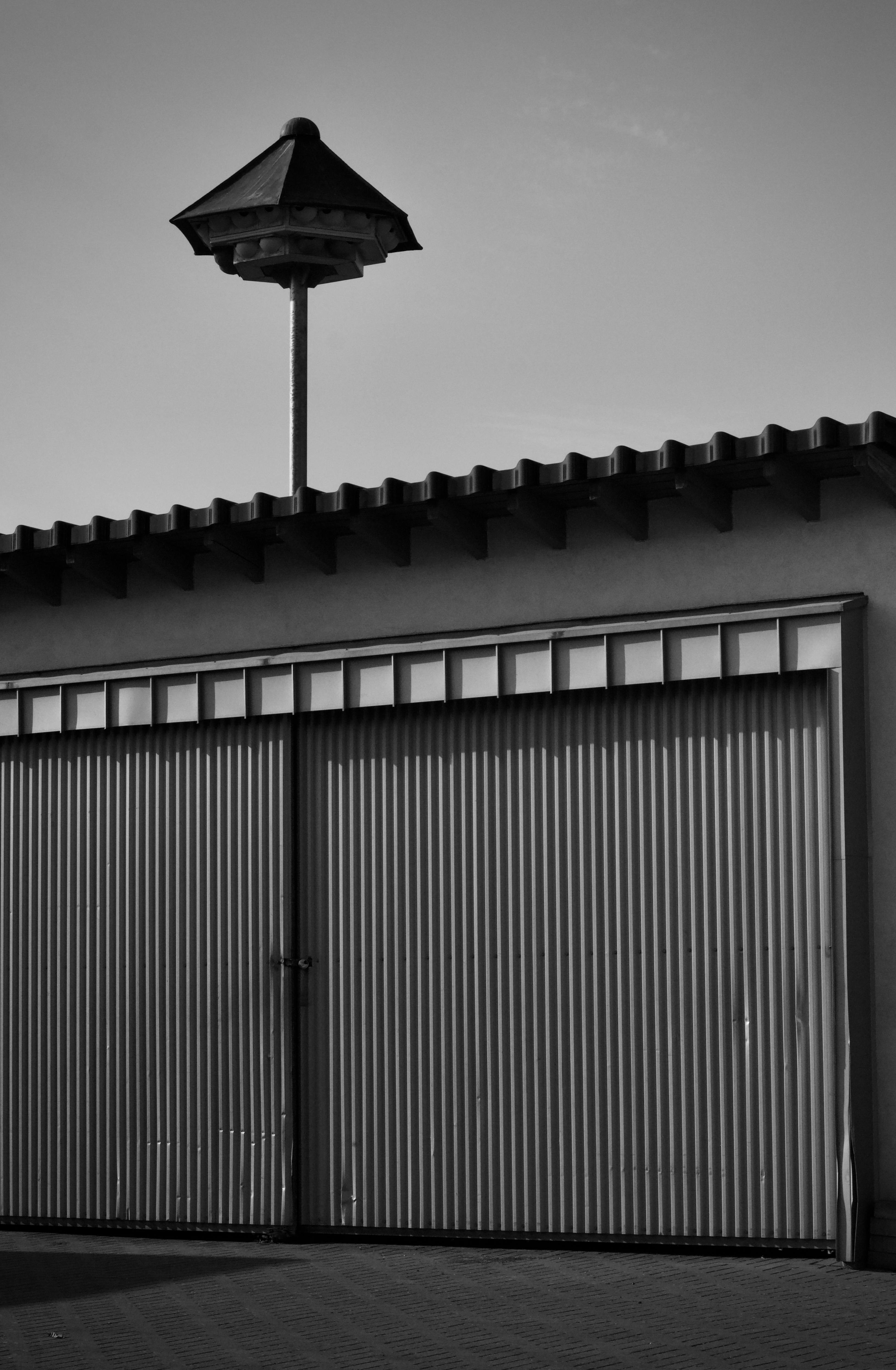 Gratis Immagine monocromatica di un garage in lamiera ondulata con una caratteristica presa d'aria sul tetto. Foto a disposizione