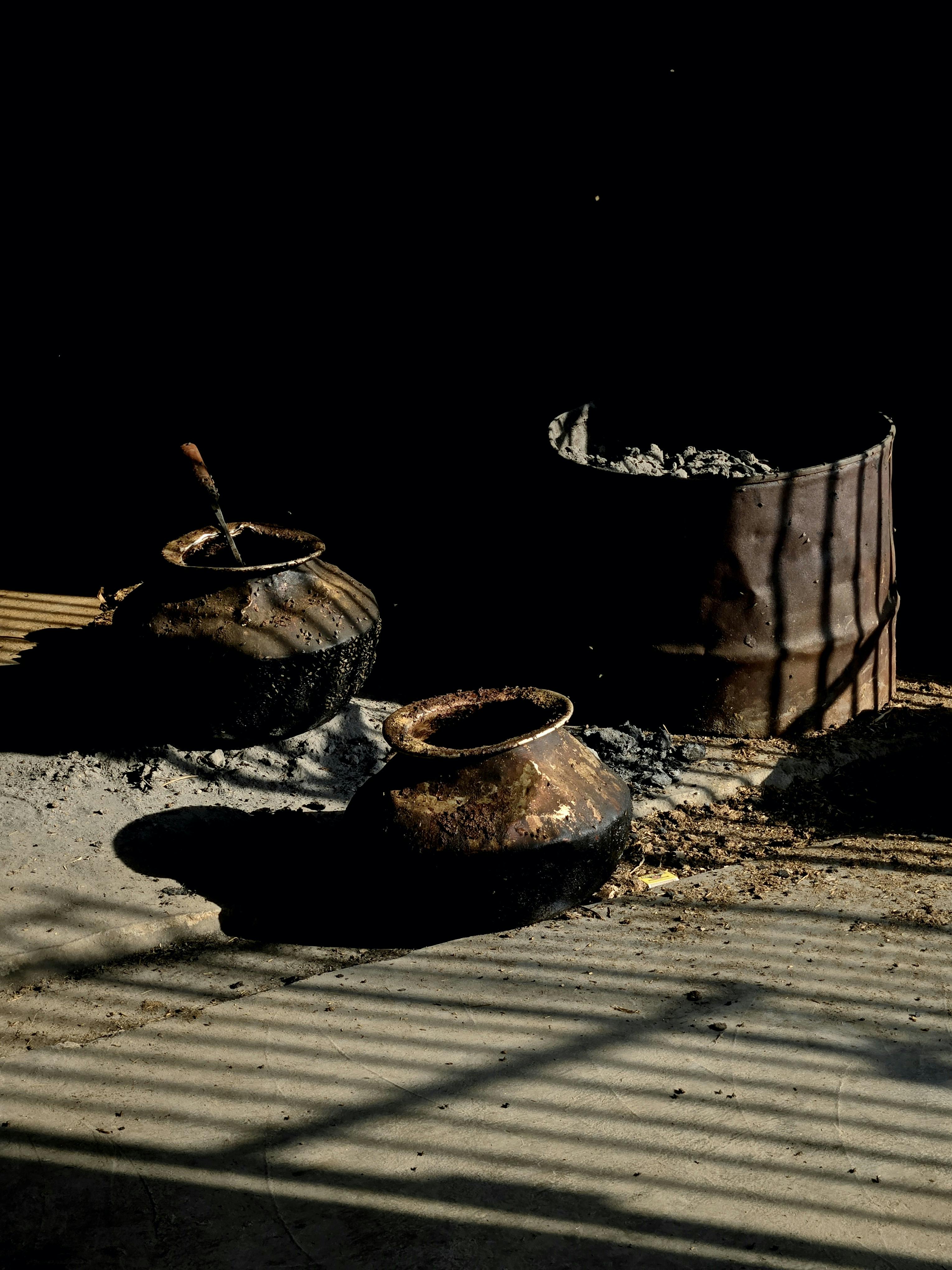 Ücretsiz Yere düşen gölgeleriyle rustik bir estetik yaratan eski çömleklerin görüntüsü. Stok Fotoğraflar