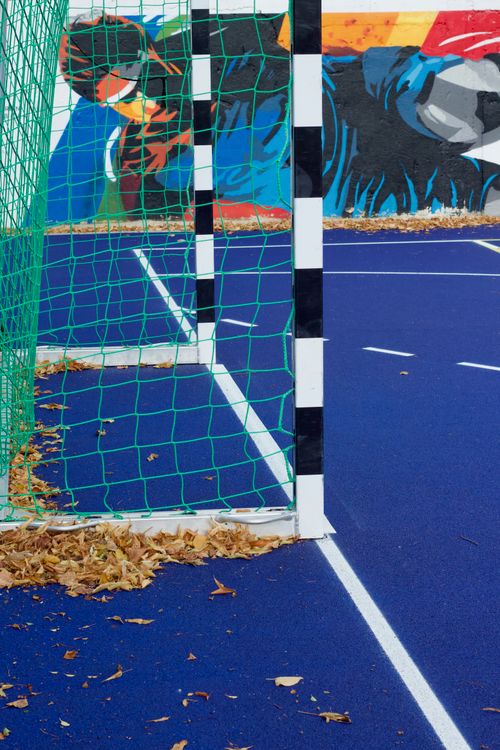 Free Vibrant outdoor soccer field with goal post and artistic graffiti mural, surrounded by autumn leaves. Stock Photo
