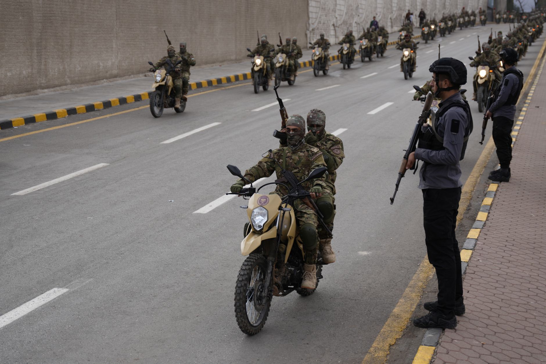 Armed soldiers in camouflage participate in a military parade in Damascus, Syria, showcasing discipline and teamwork.
