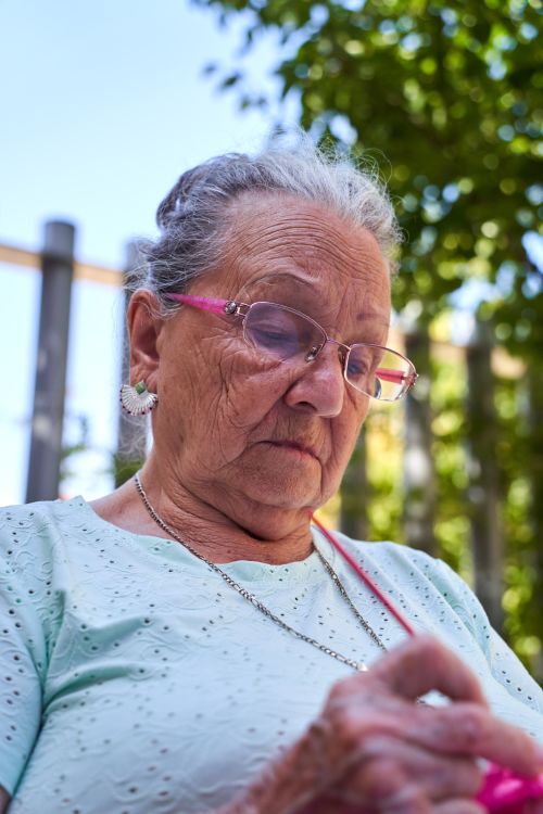 Free Senior woman enjoying knitting in a sunny outdoor setting in San Sebastián de los Reyes. Stock Photo