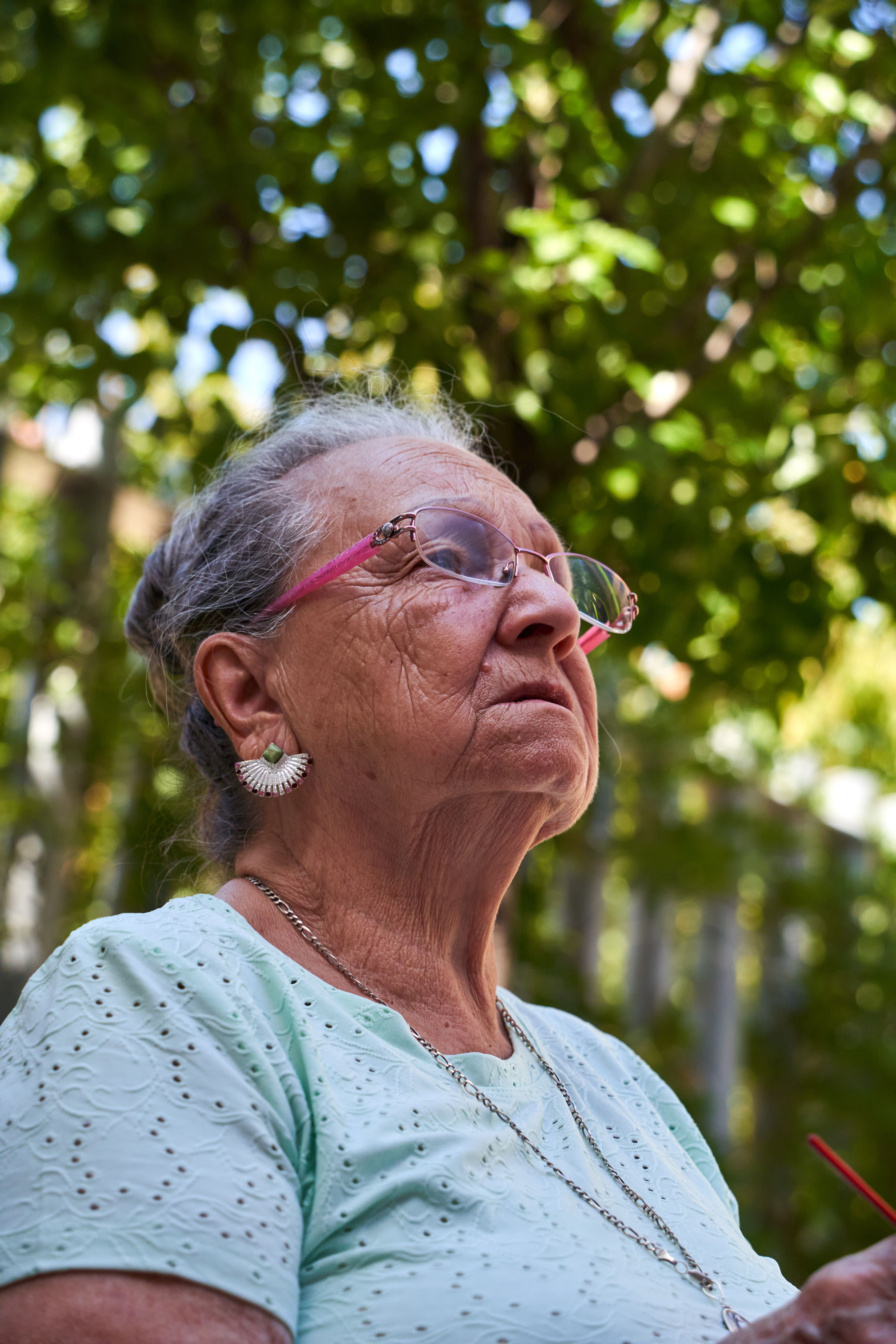 Senior woman enjoying knitting in a sunny garden setting in San Sebastián de los Reyes.
