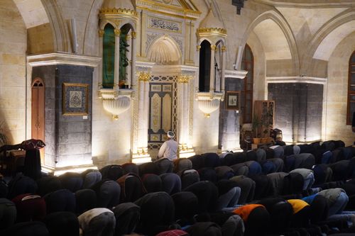 Free A group of worshipers engaged in prayer inside a historic mosque in Gaziantep, Türkiye, showcasing Islamic architecture. Stock Photo