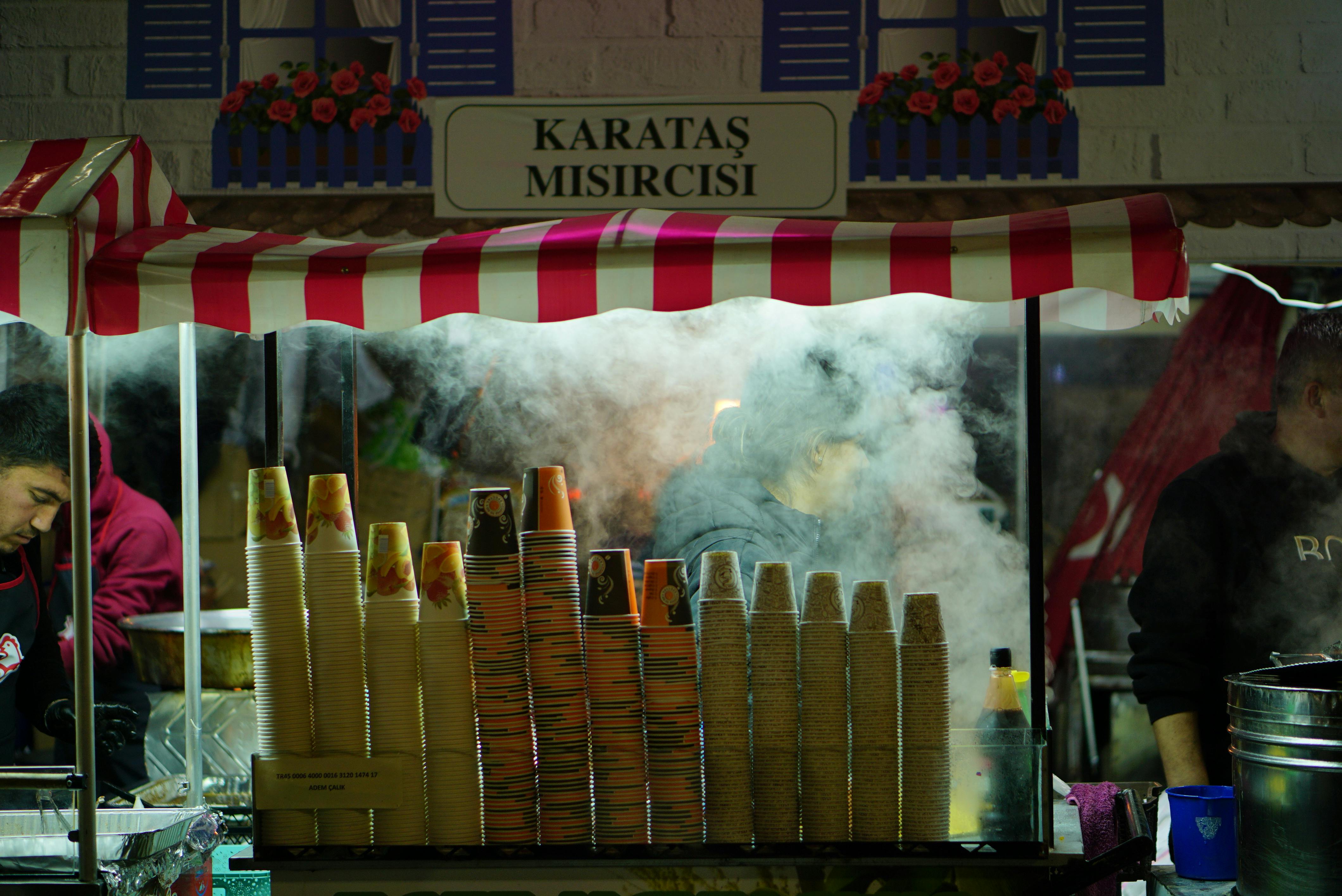 Captivating night market scene in Gaziantep, featuring a vibrant street food stall with steaming cups.