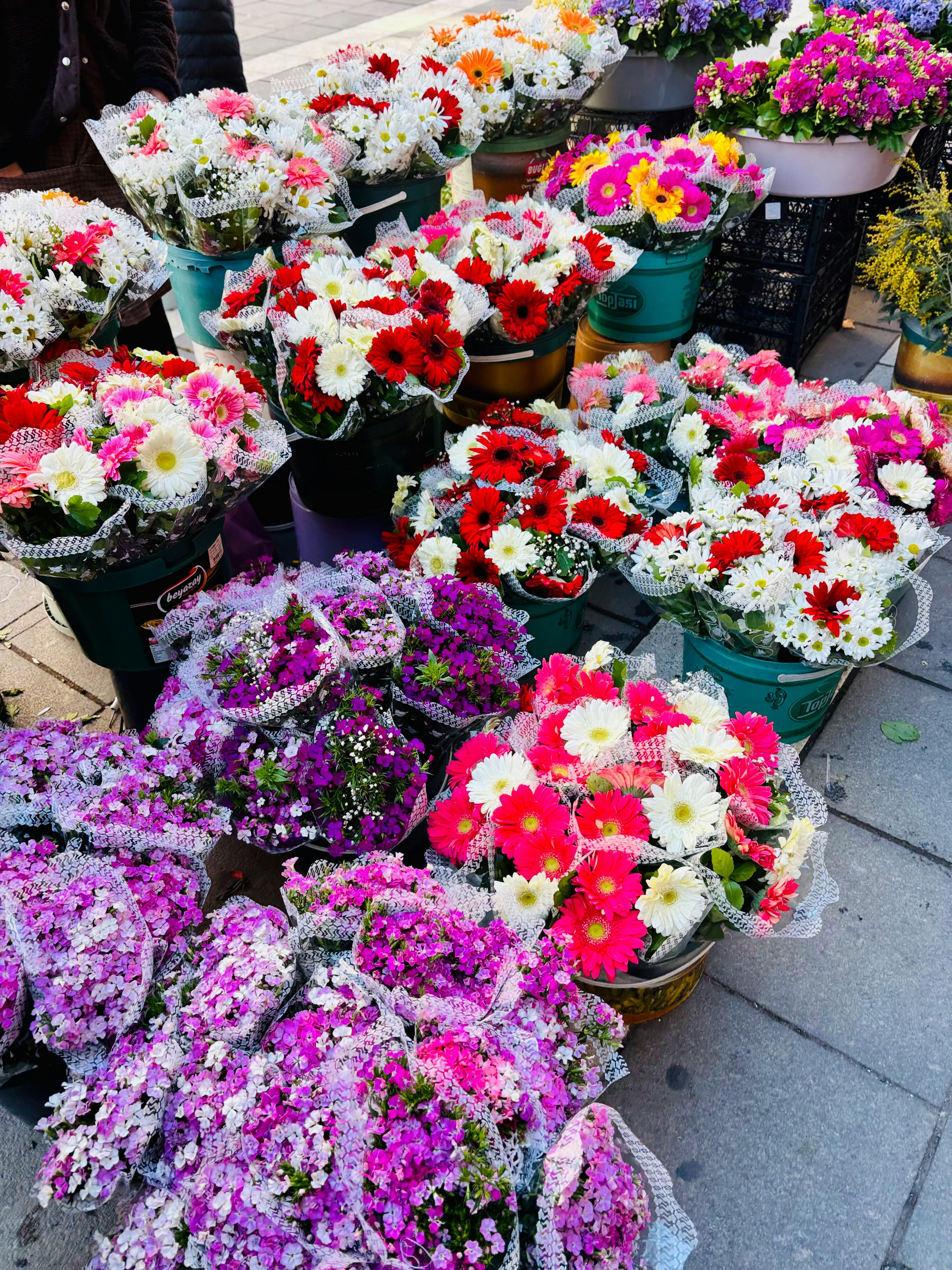 [ColoSach]-a-colorful-array-of-flowers-in-bouquets-at-an-outdoor-market,-showcasing-diverse-floral-types.