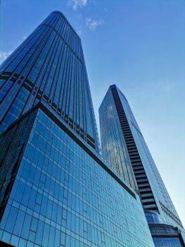 Tall skyscrapers with modern glass facades under a clear blue sky.