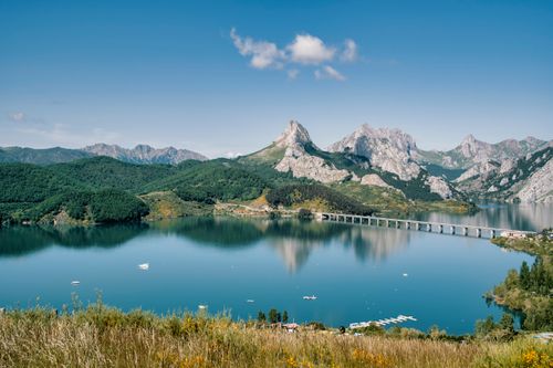 Free Breathtaking view of Riaño Reservoir with surrounding mountains in León, Spain, on a clear summer day. Stock Photo
