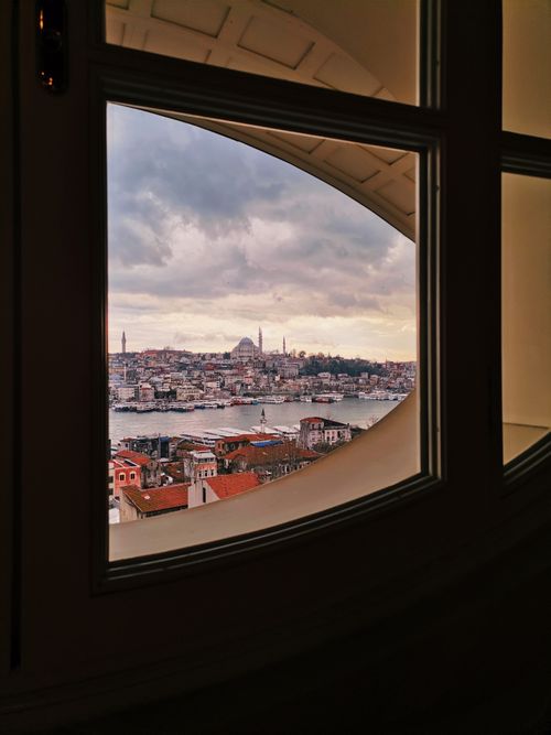 Free Breathtaking view of Istanbul's skyline and Bosphorus through an arched window at sunset. Stock Photo