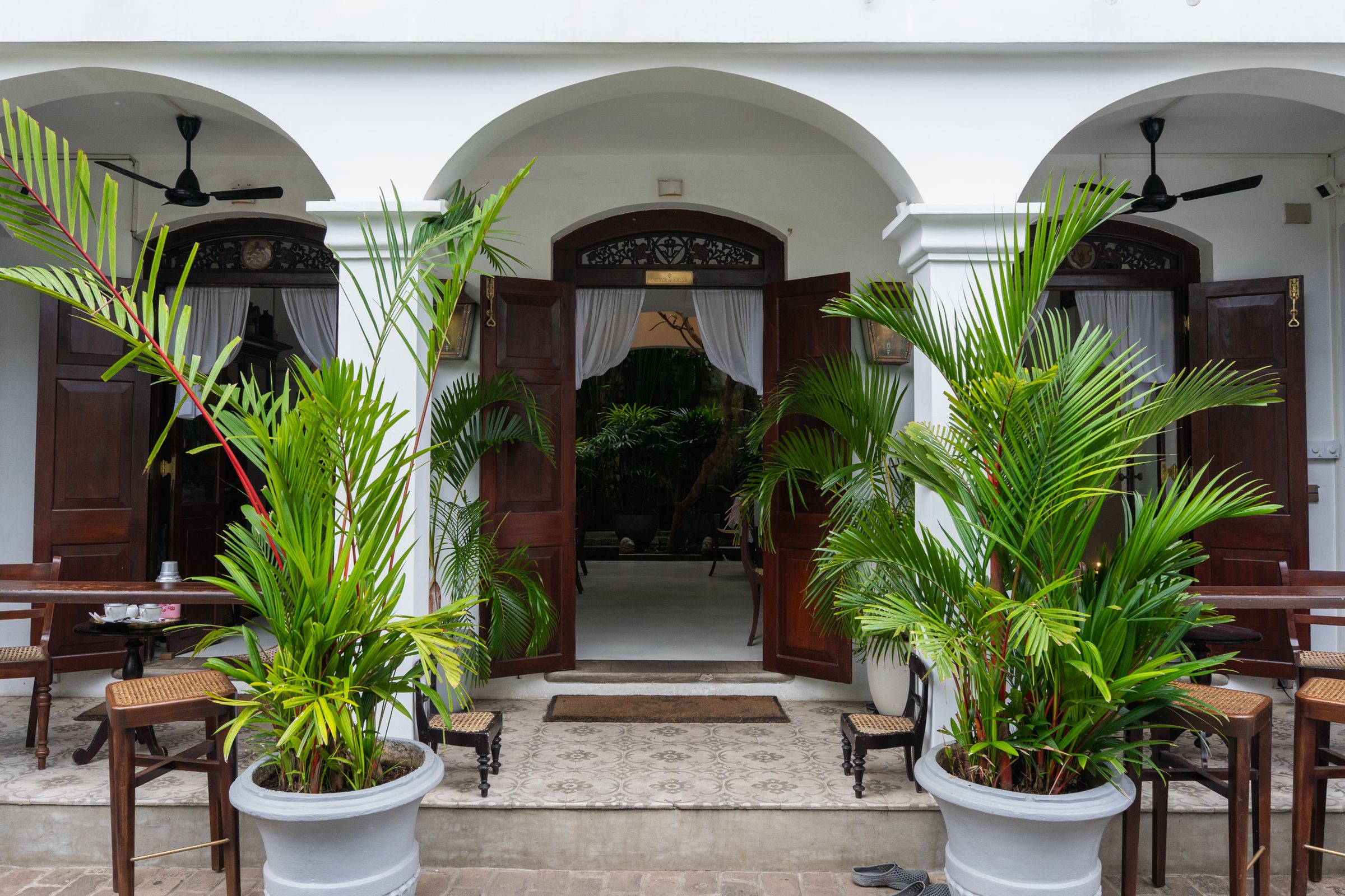 An elegant colonial entrance framed by lush plants