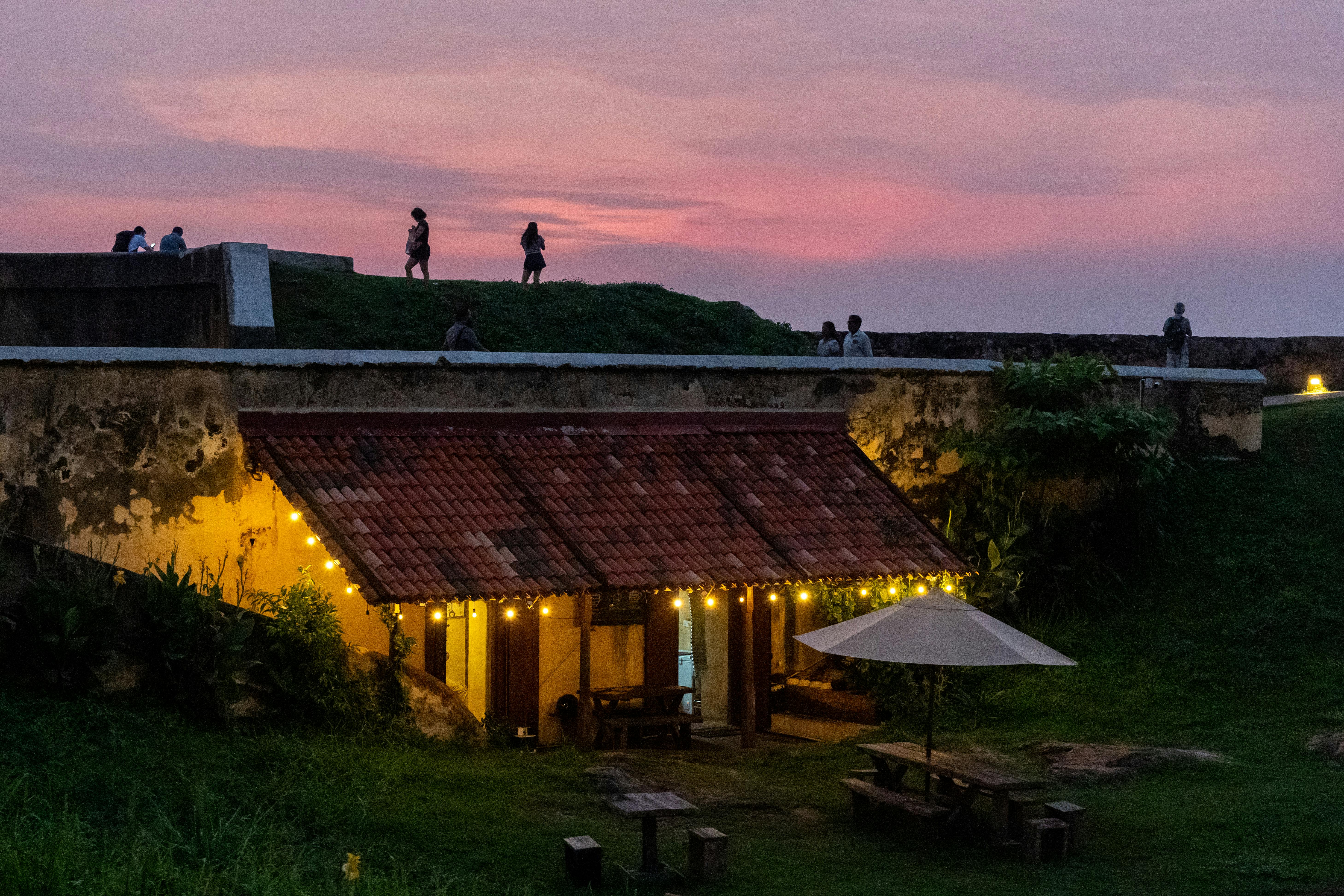 Ancient stone ramparts of Galle Fort at sunset with Indian Ocean waves crashing below
