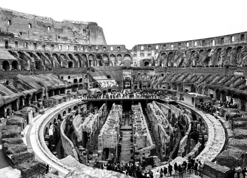A striking black and white photo showcasing the interior of Rome's historic Colosseum.