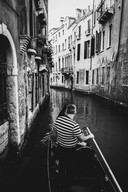 Free Explore Venice's historic charm with a classic gondola ride through narrow canals. Stock Photo
