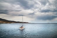 Sailing Boat on Open Sea under Cloudy Sky