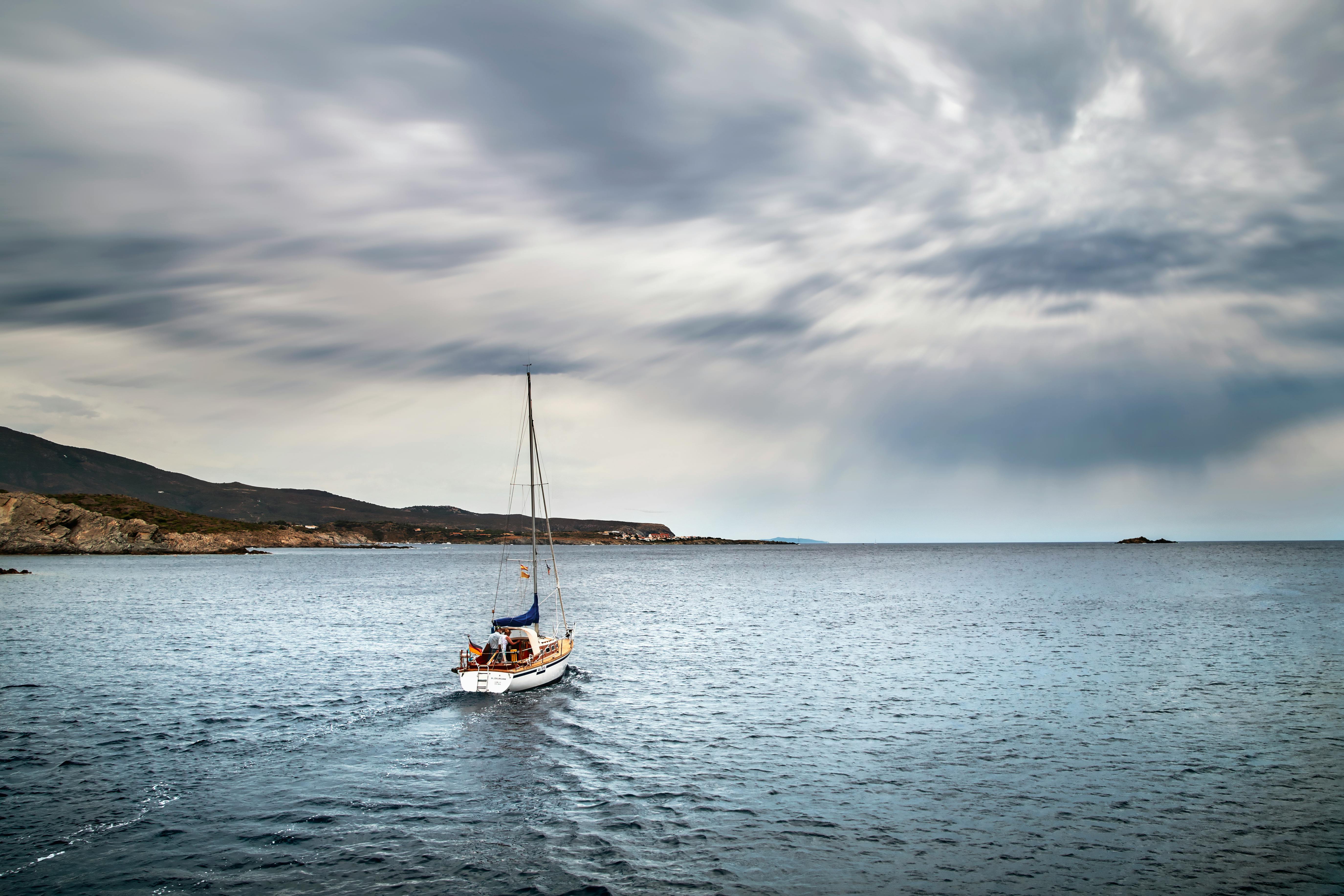 Sailing Boat on Open Sea under Cloudy Sky